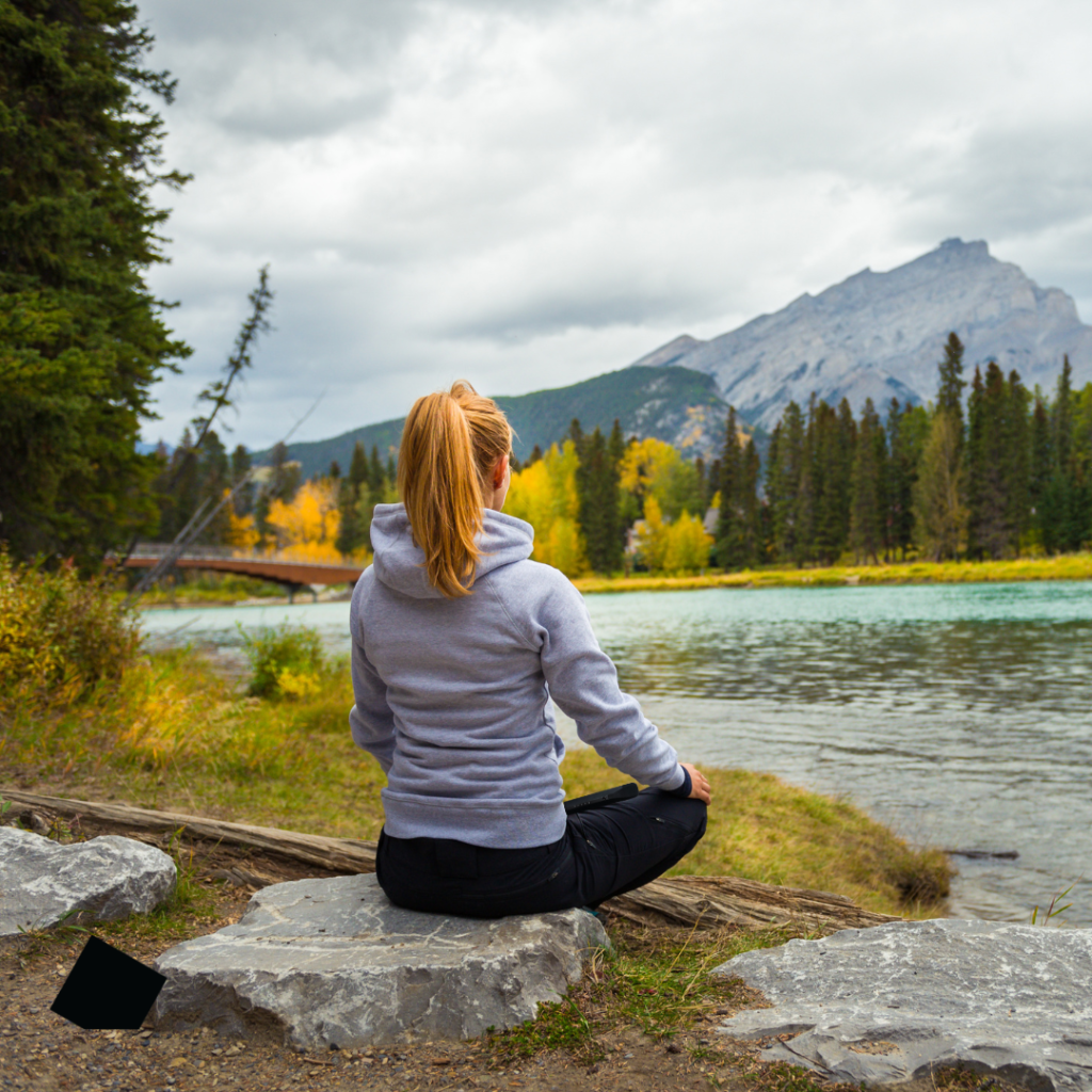 Woman Sitting by a River