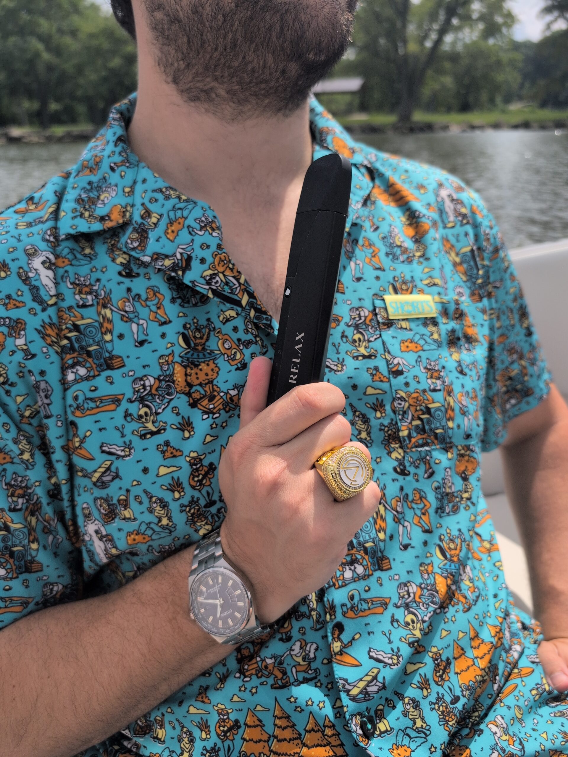 Man in colorful shirt holding dry herb vaporizer